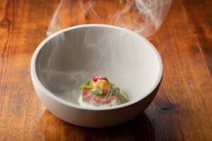 Ihr Vorgeschmack auf das Restaurant KITCHEN LIBRARY: Würziger Dry Aged Tatar mit Onsen-Ei, Rauch und marinierten Rosenblüten.